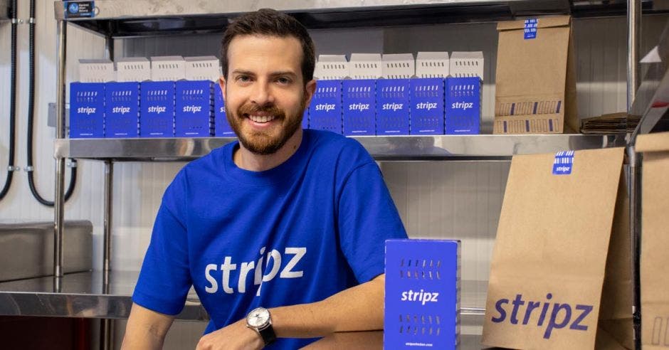 Un hombre de barba con una camisa azul