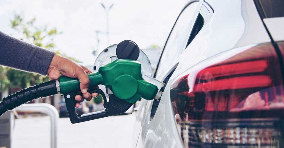 Una persona echando gasolina en el tanque