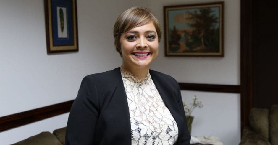 Una mujer con blaser negro y pelo corto sonriendo