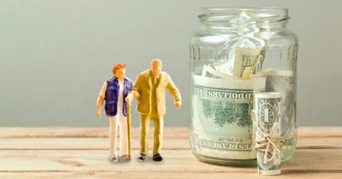 Muñecos de adultos mayores junto a jarrón con dinero
