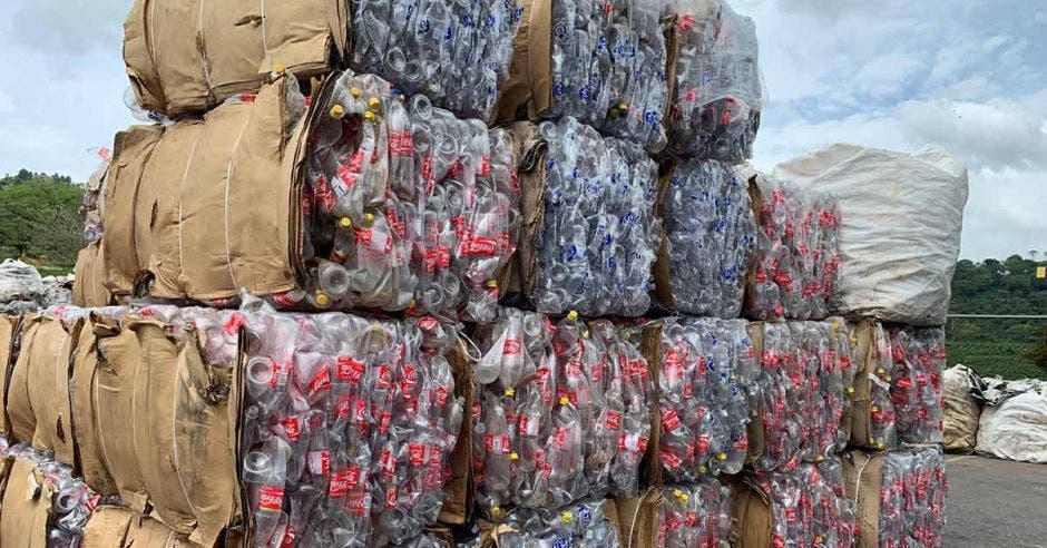 Botellas de Coca Cola recicladas y apiladas en cuadros compactos