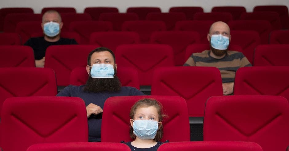 Personas en el cine con mascarillas