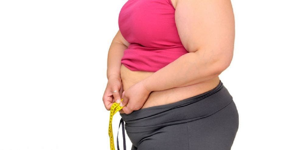 Una mujer obesa midiéndose