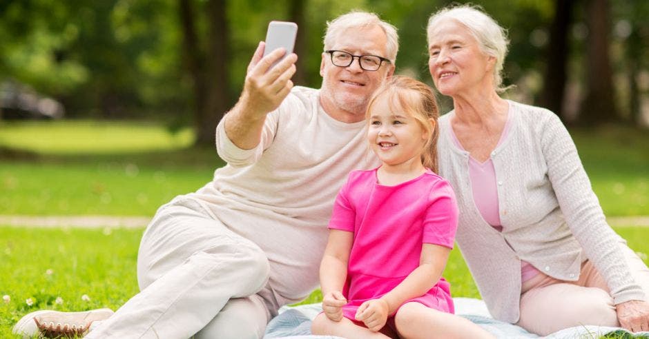 Adultos mayores y jóvenes viendo celular