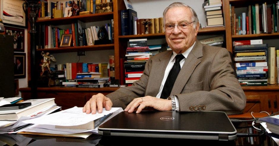 Hombre de traje frente a libros