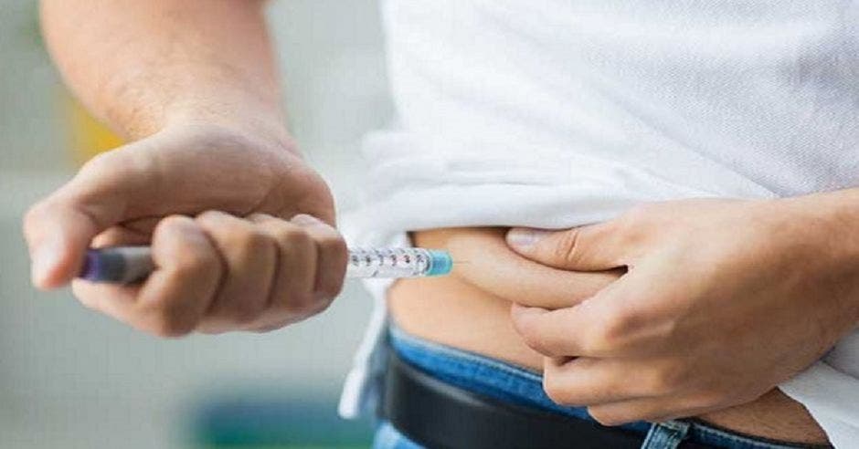 Una persona inyectándose insulina en su estómago
