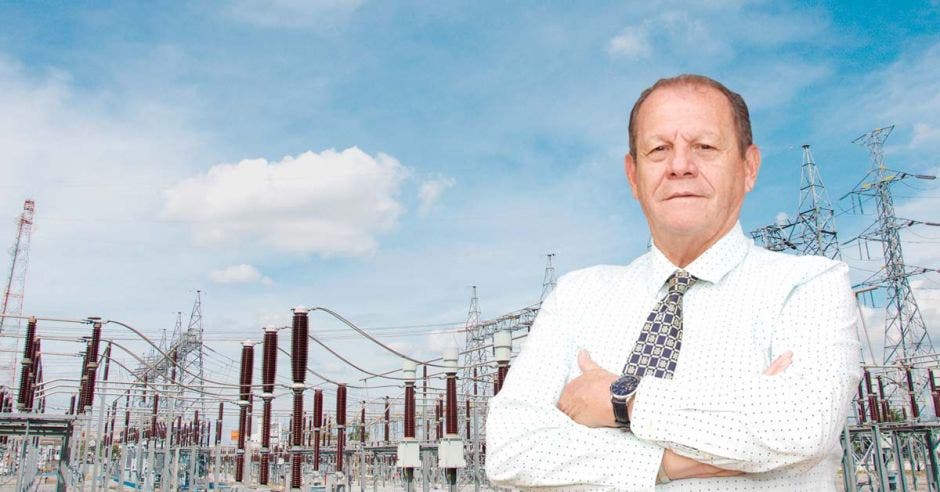 un hombre mayor con camisa blanca y corbata sobre un fondo de antenas