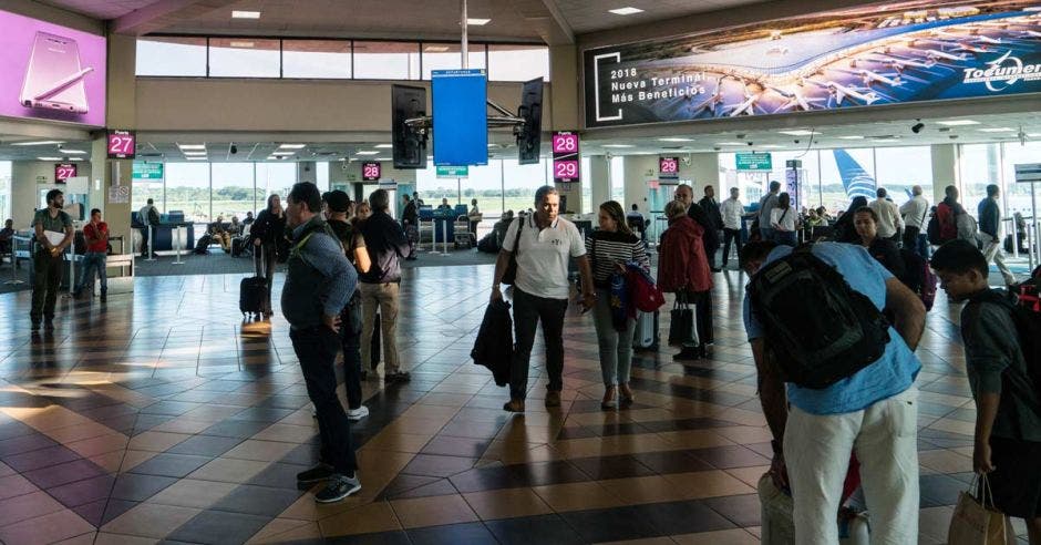 una multitud recorre el lobby de un aeropuerto