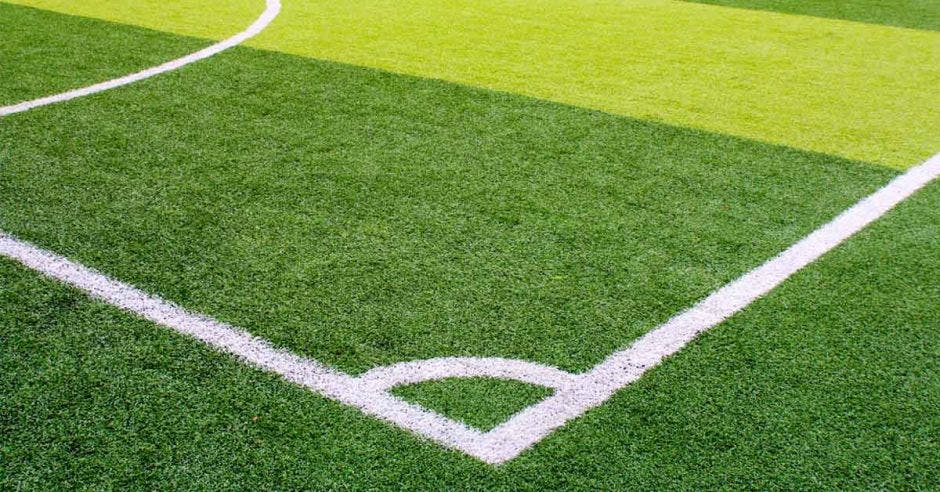 un campo deportivo de césped sintético verde con línea blanca tomada desde arriba