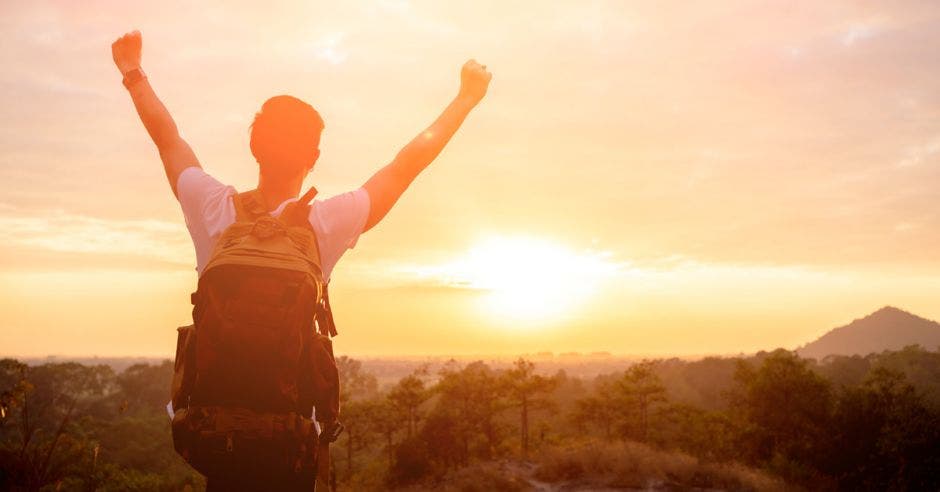 Un hombre con las manos levantadas hacia el sol