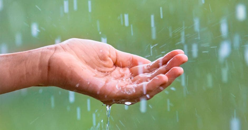 una mano recogiendo agua de lluvia