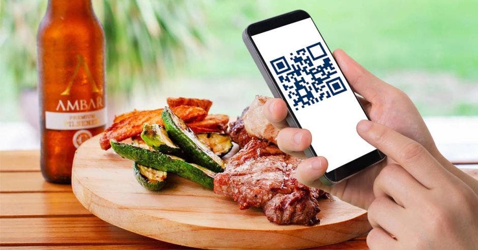 Una persona escanea con código QR el menú de un restaurante