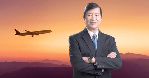 un hombre de corbata y saco sobre un fondo que tiene un avión