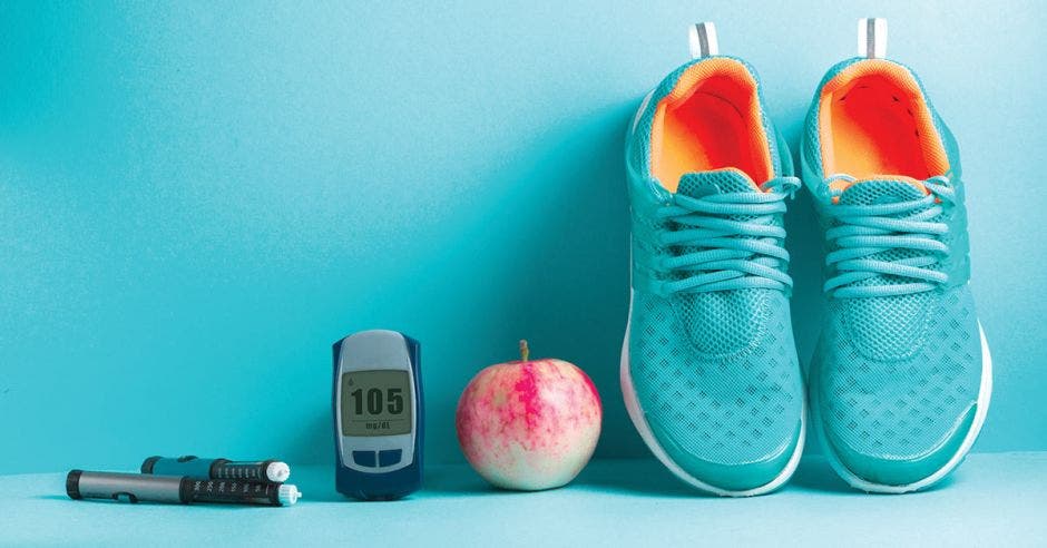 Una manzana, unas tenis y unos aparatos para medir la glucosa en sangre