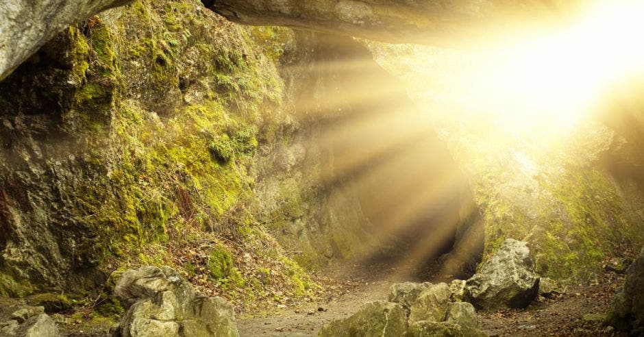 Rayos de luz iluminan la entrada de una cueva