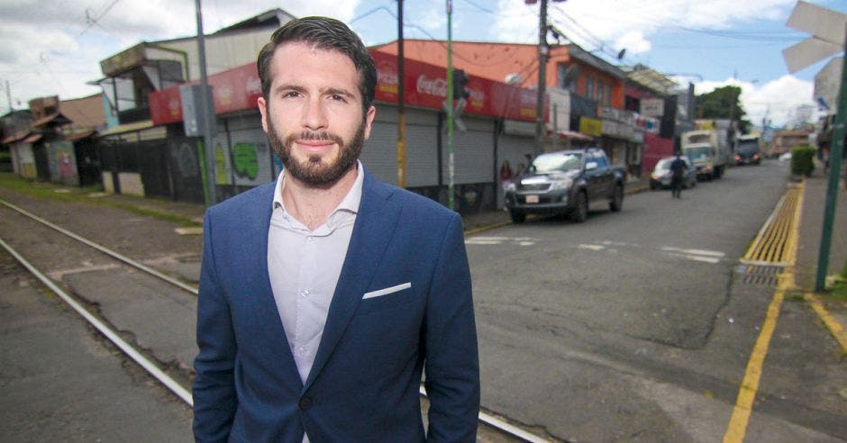 un hombre de camisa blanca, saco azul y barba