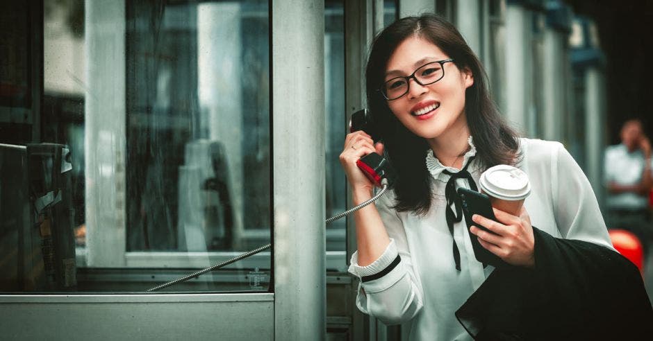 Mujer usando un teléfono público