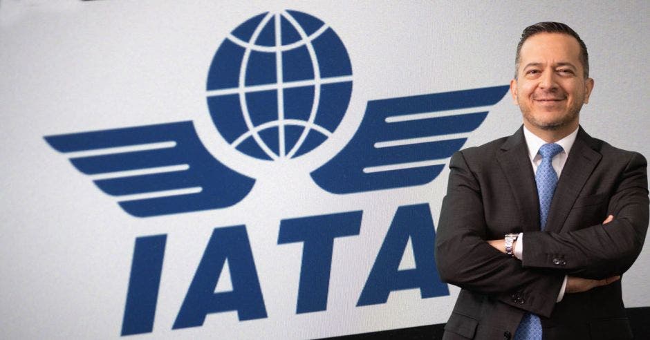 Un hombre de traje y corbata sobre el logo de la IATA