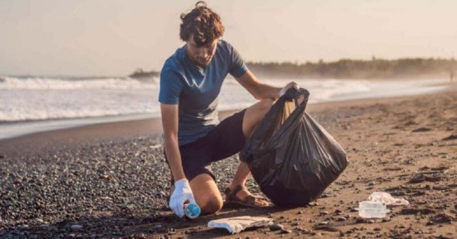 playa y persona recogiendo basura