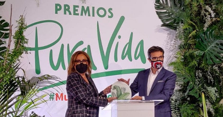 Dos personas reciben un premio en un estrado