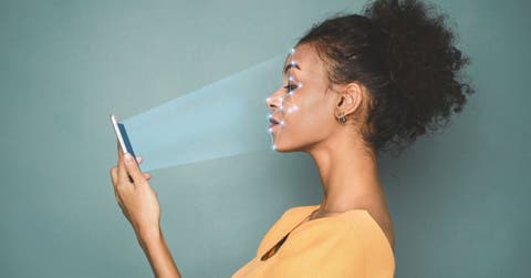 Identificación biométrica. Mujeres afroamericanas escaneando la cara con un sistema de reconocimiento facial en un smartphone