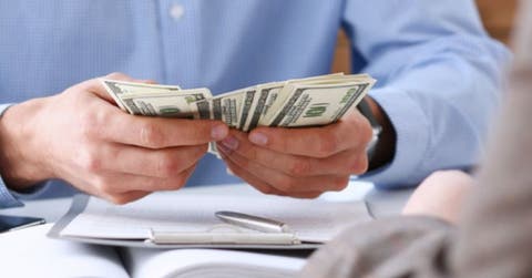 Persona sostiene billetes en sus manos
