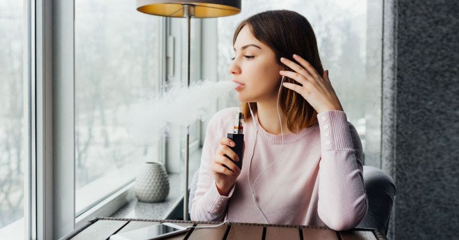 Retrato de una joven usando un vaporizador