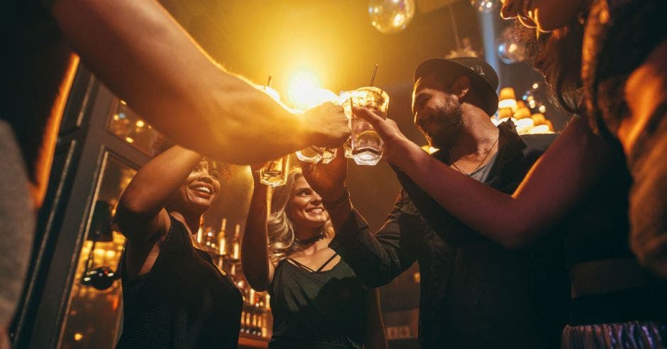 Imagen en ángulo bajo de un grupo de amigos disfrutando de bebidas en el bar juntos