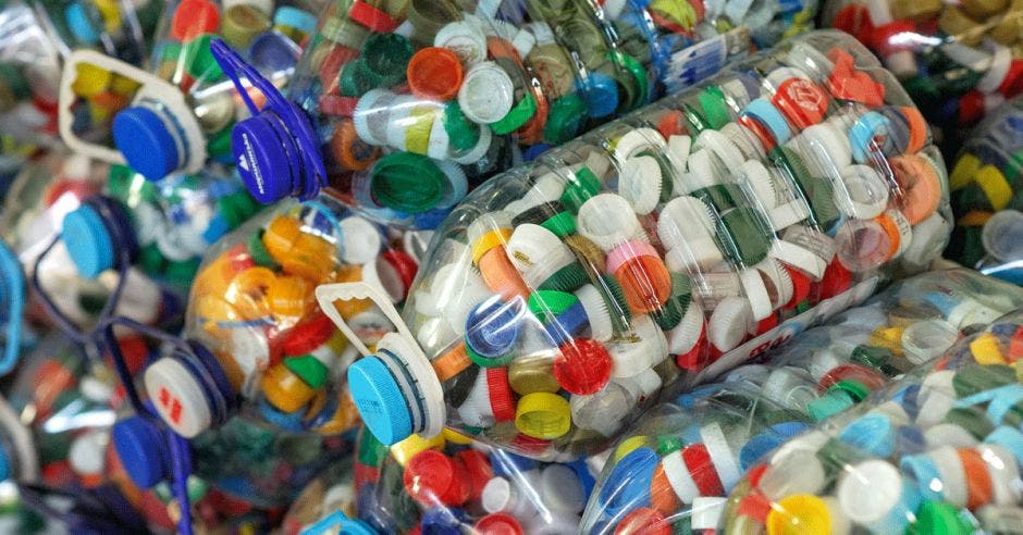 varias botellas de plásticos transparentes llenas de tapitas de plástico multicolor
