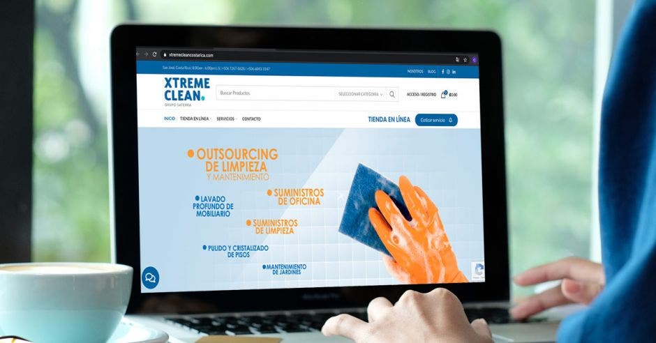 página principal del sitio web de Xtreme Clean. Un hombre navega en una computadora portátil.