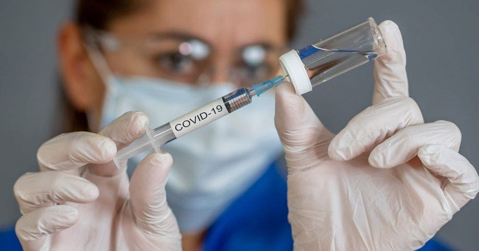 Una persona sosteniendo una vacuna contra el Covid-19