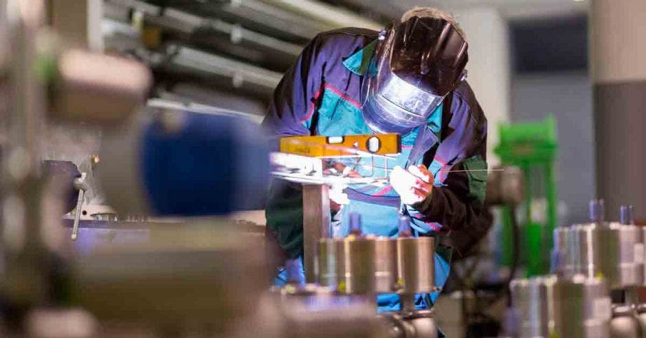 un hombre realiza trabajos de soldadura dentro de una fábrica