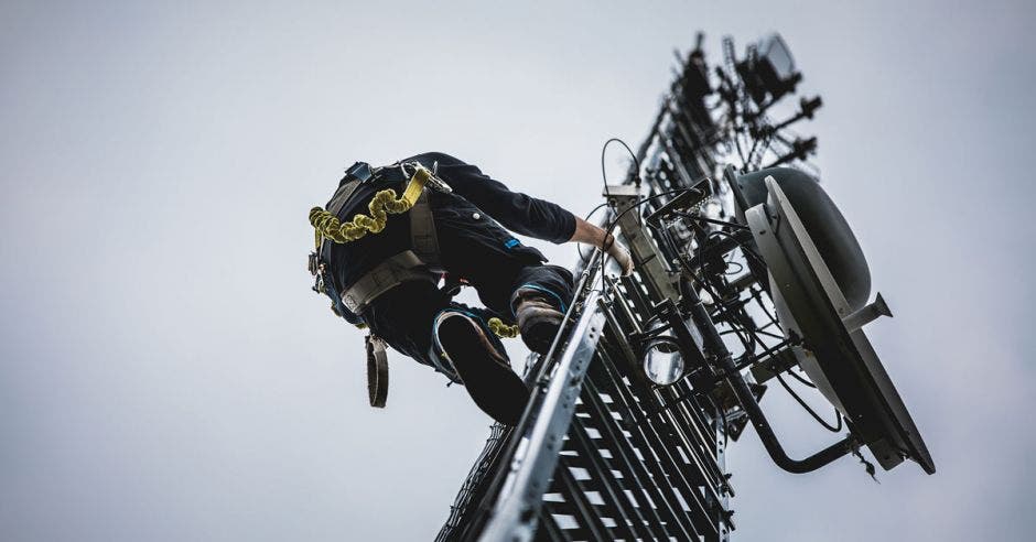 Trabajador subiendo una antena de telefonía móvil