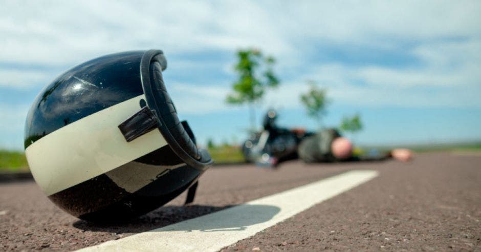 casco de motociclista tirado en la carretera