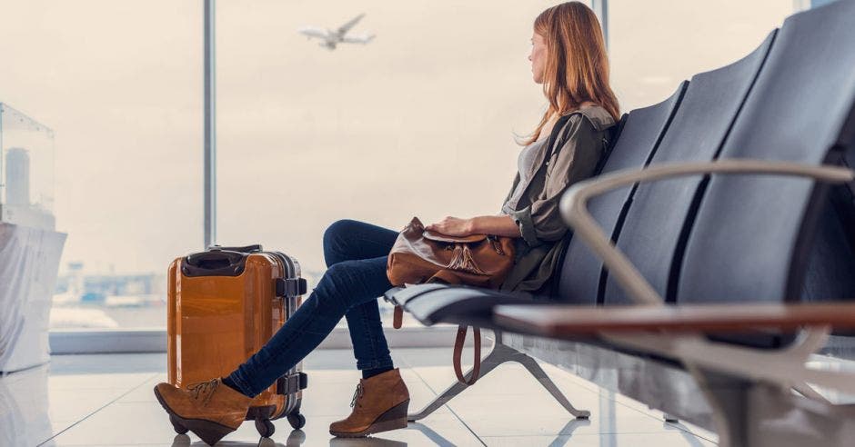 una mujer sentada en el lobby de un aeropuerto esperando su vuelo