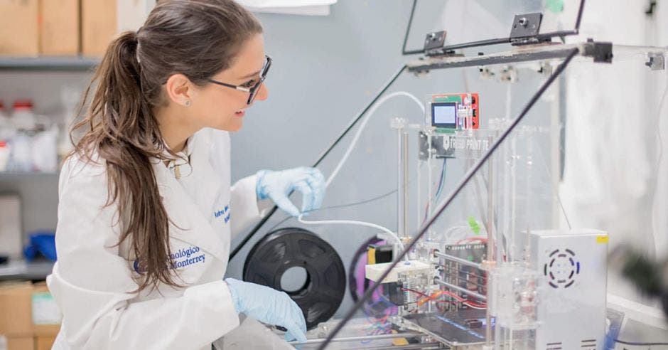 una mujer con una bata blanca y anteojos en un laboratorio