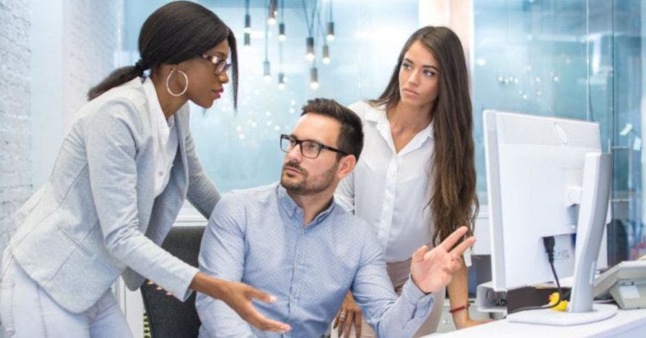 jóvenes esudiantes platicando frente a un computador