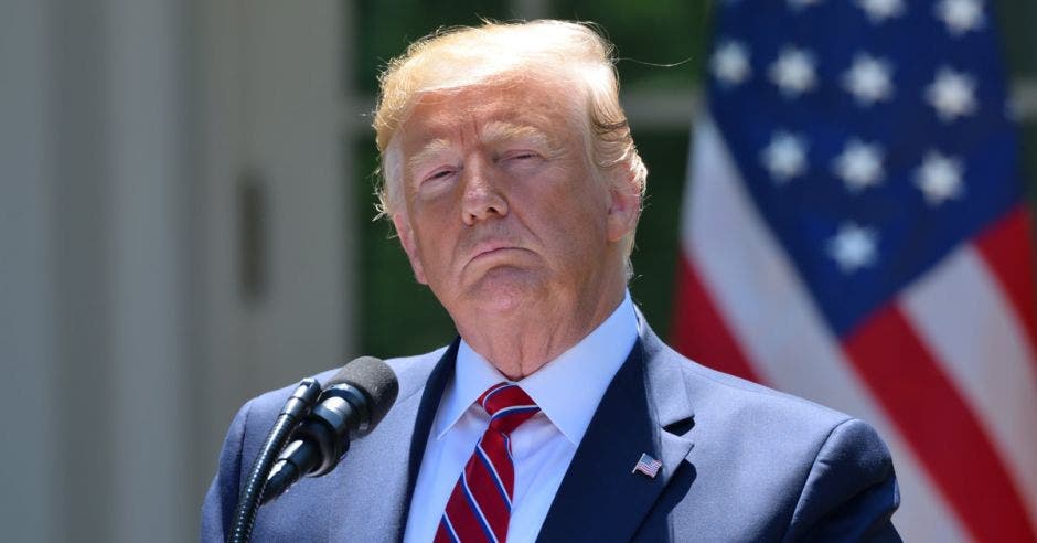 un hombre de pelo rubio, saco y corbata roja