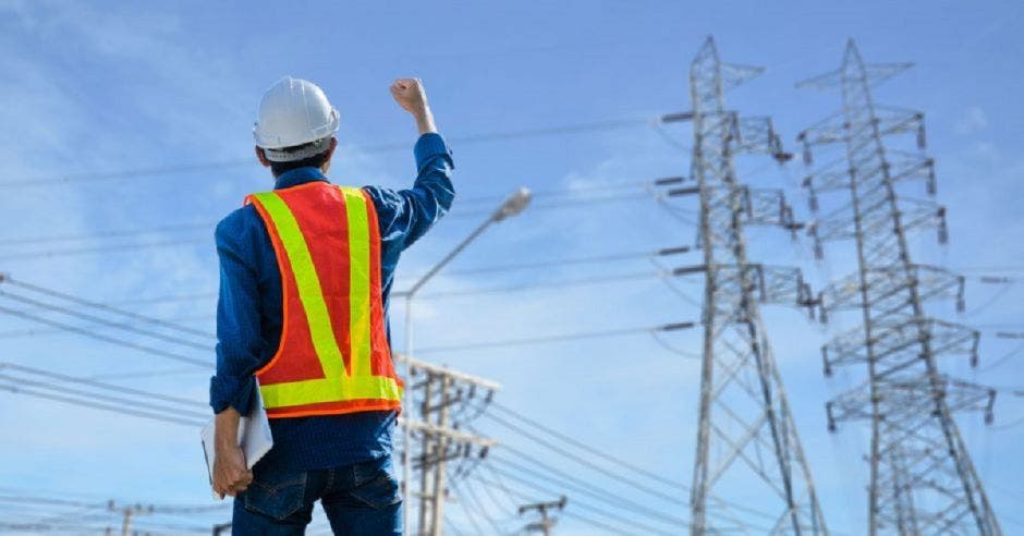 Trabajador frente a torre eléctrica