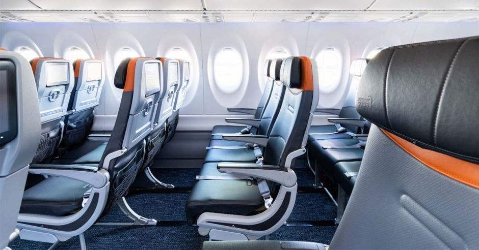 Interior de un avión. Asientos de cuero negro con detalles en naranja