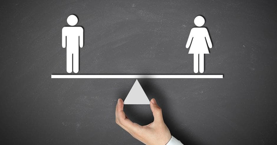 Persona sostiene balance en género hombres y mujeres