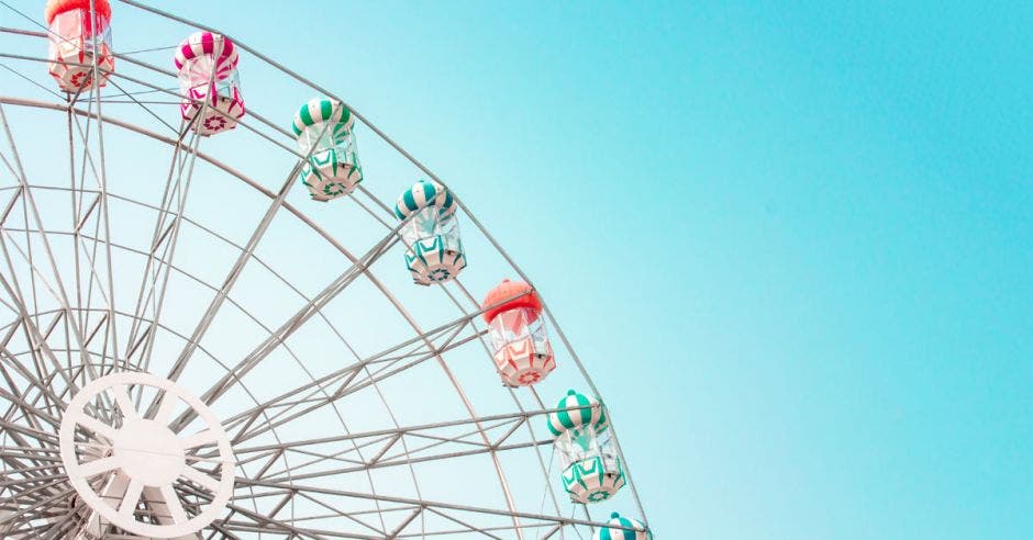 Rueda de hierro colorido del parque de atracciones en el fondo azul del cielo