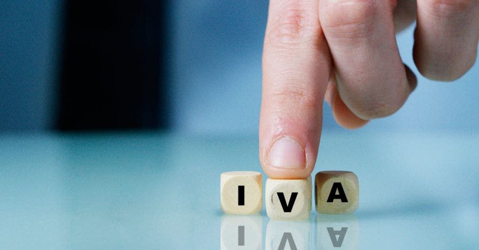 Dedo de persona sobre dados que dicen IVA