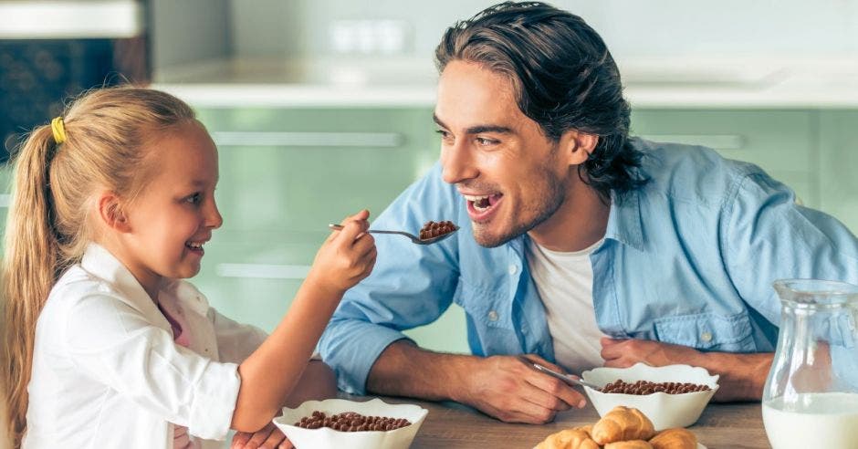 Niña y papá comiendo cereal