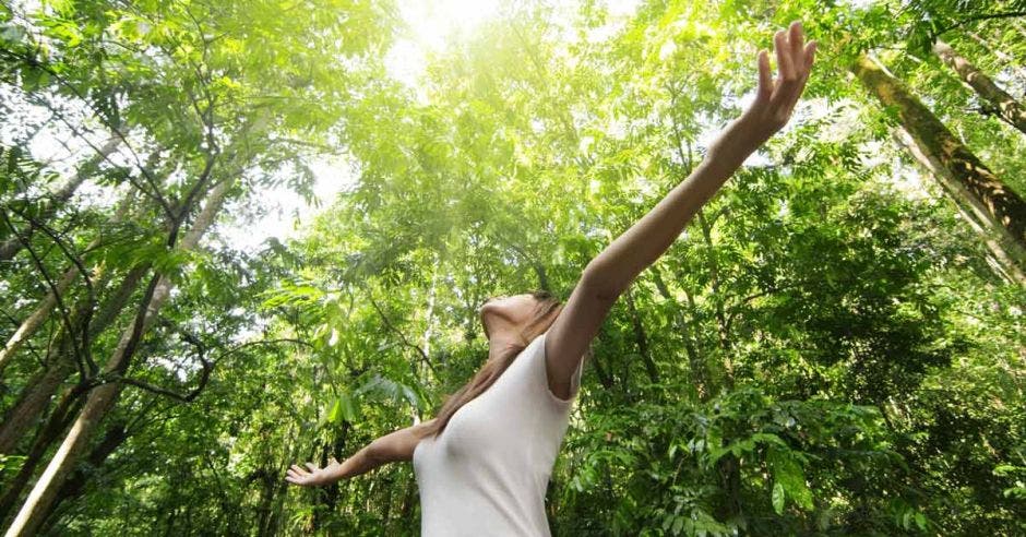 una mujer toma aire sobre un fondo verde