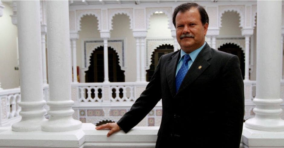 un hombre de bigote, saco y corbata