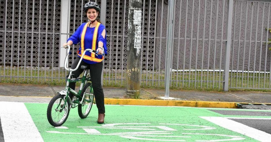 una mujer en bicicleta sobre una demarcación verde