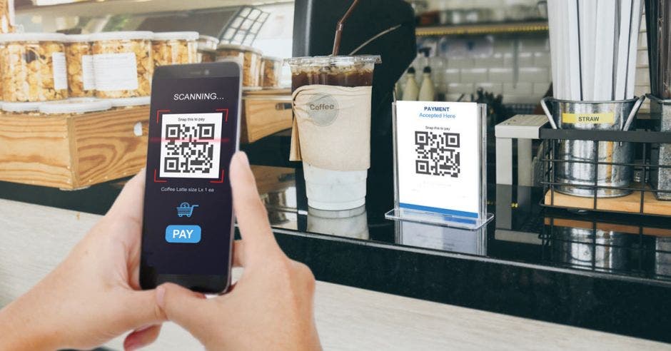 persona escaneando un código QR con su celular para hacer un pago