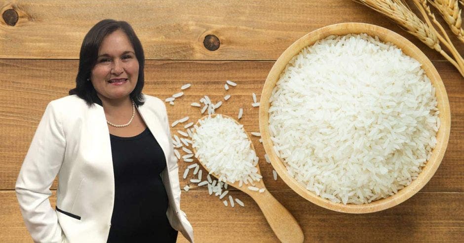 una mujer de blaser blanco y traje negro junto a una cuchara y un tazón lleno de arroz