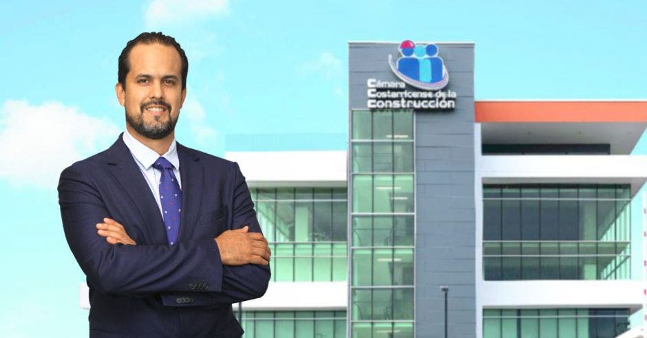 Hombre de traje y corbata frente a edificio de la Cámara de la Construcción